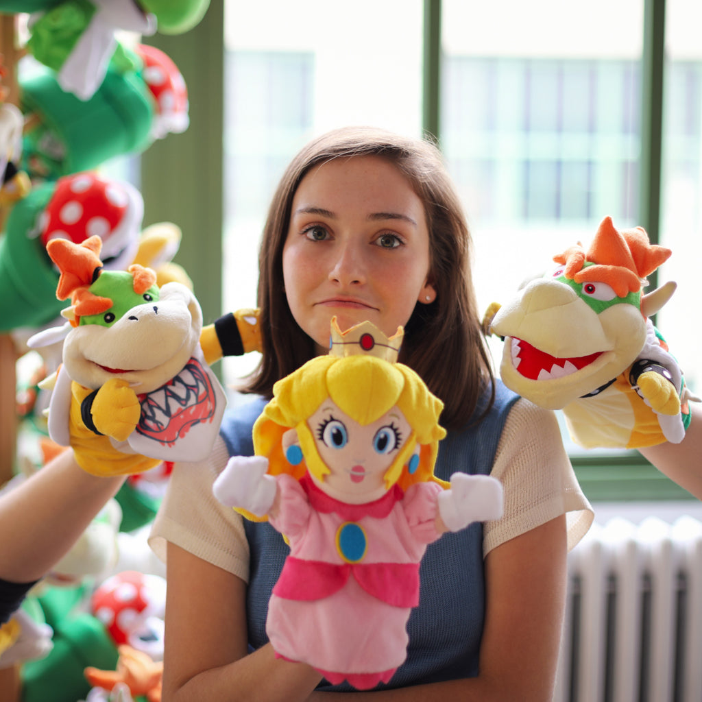 Super Mario Bros: model with Princess Peach, while Bowser and Bowser JR puppets are lurking in the background